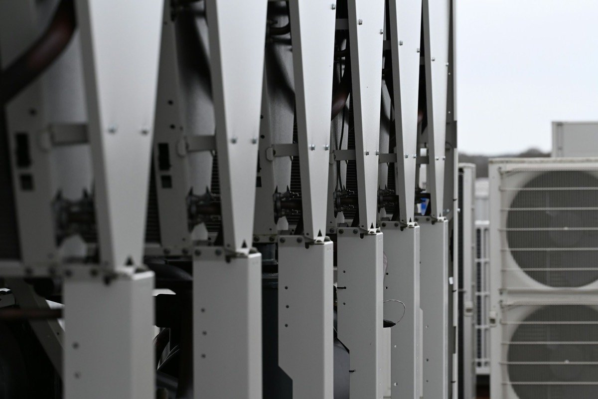 Outdoor heat pump units lined up beside a building