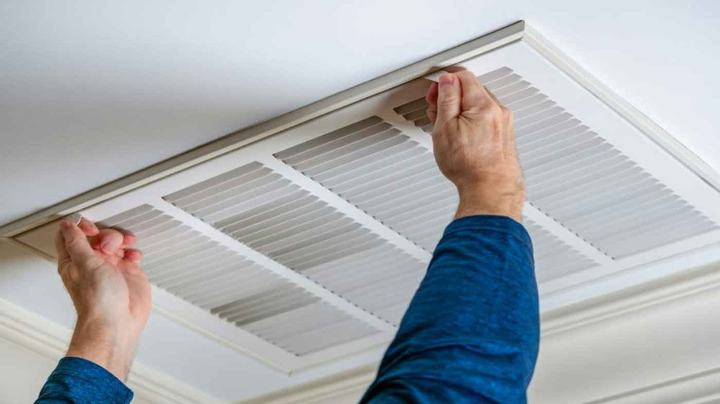 Arctic Wind HVAC technician replacing a home air filter during an HVAC tune-up
