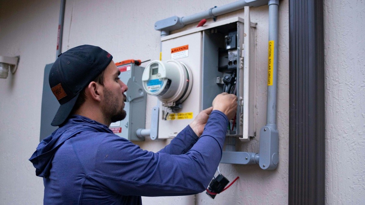 Technician installing and wiring a home thermostat control